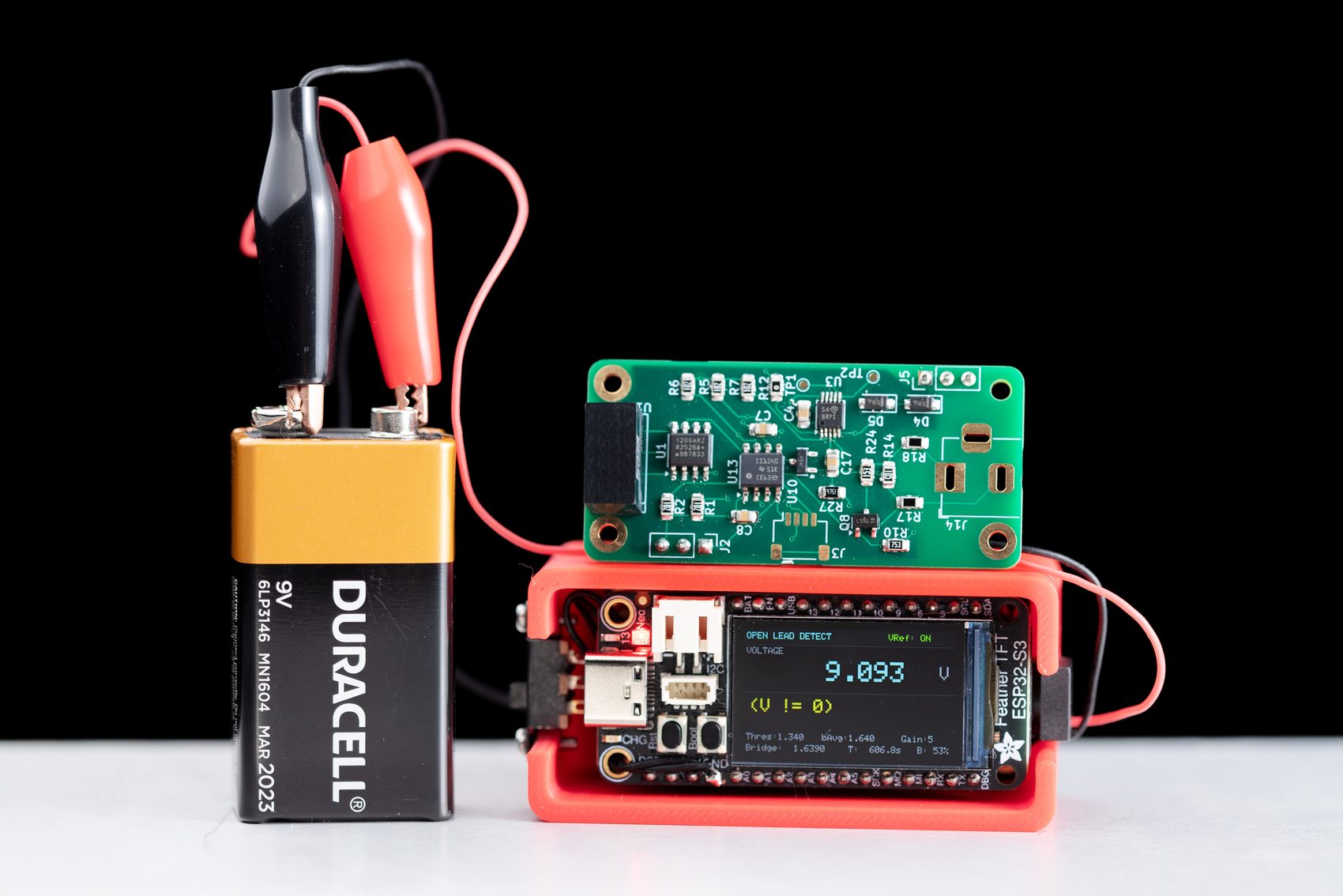 The standalone build powered by a 9 V battery, its screen reading OPEN LEAD DETECT, 9.093 V, with its custom PCB above.